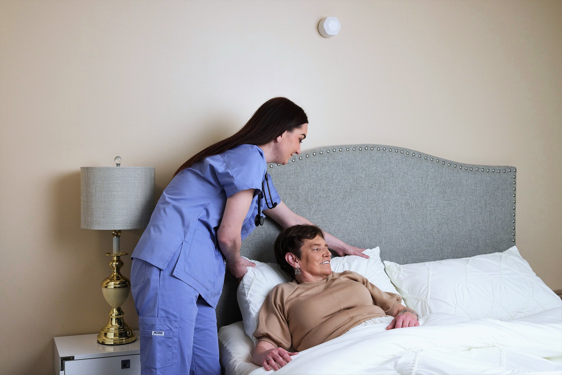 A care team member at the bedside reviewing a resident's trend