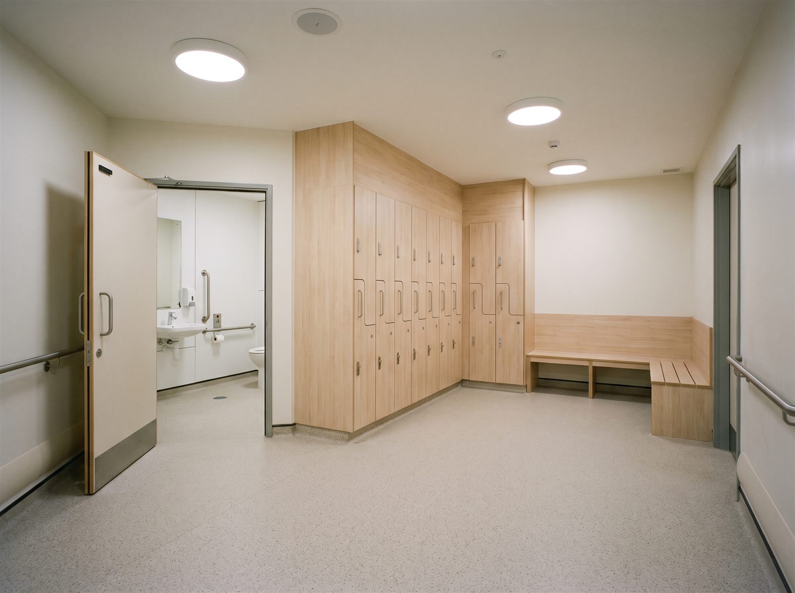 An empty staff locker room with an accessible toilet cubicle