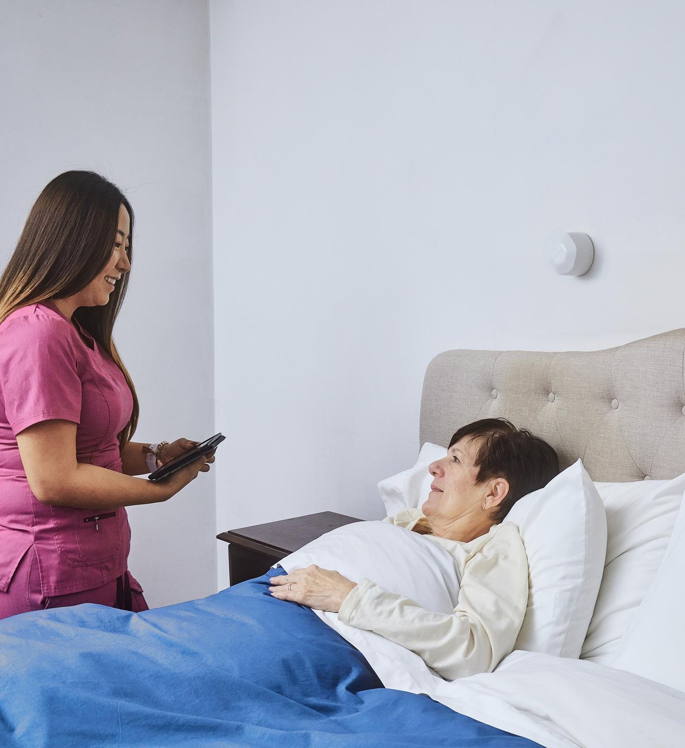 A nurse with a resident; the XK300 on the wall behind